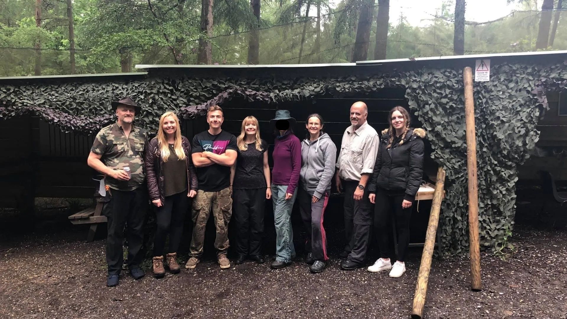 Team building in Kent - group posing together at a woodland base camp