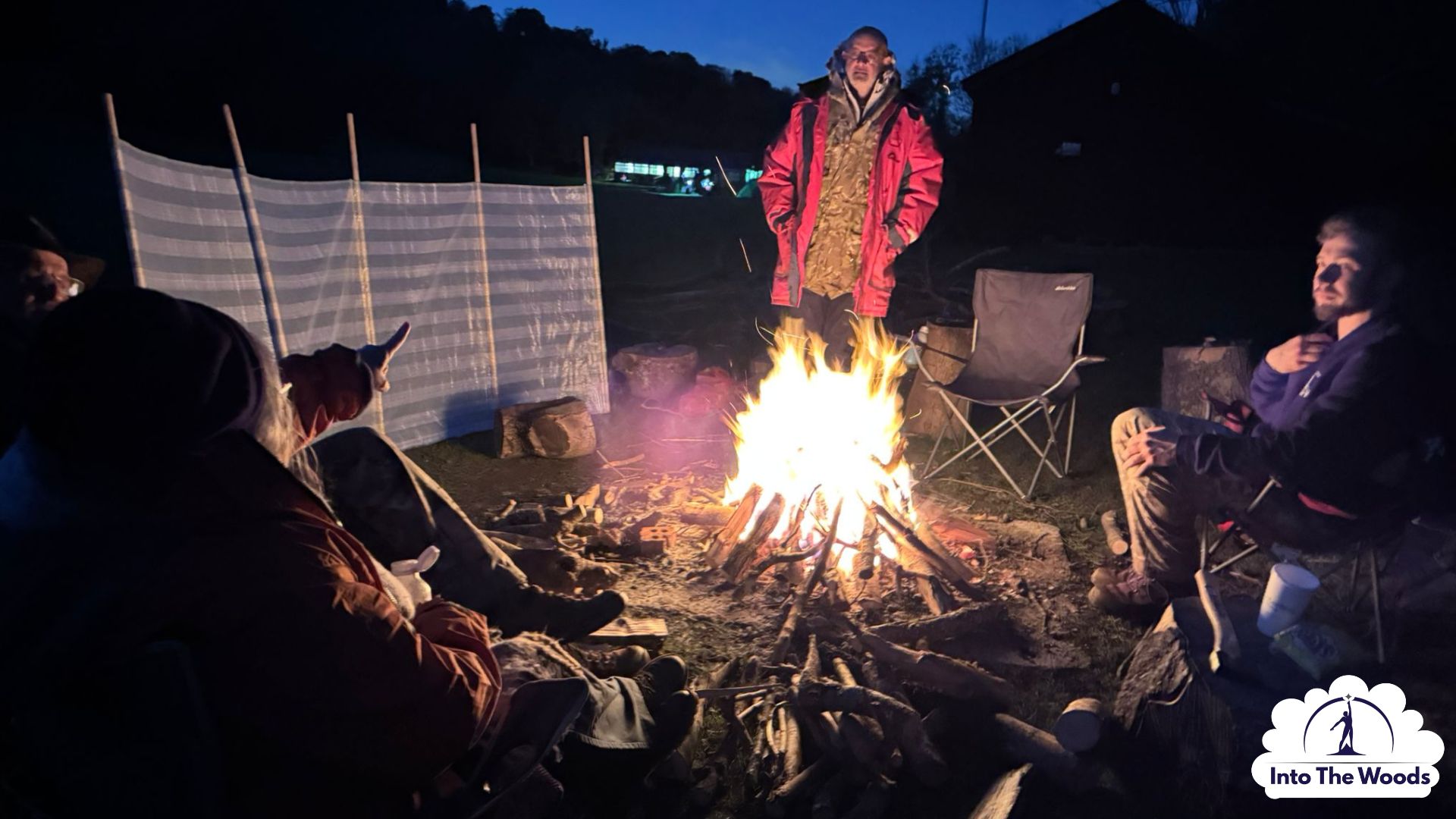 Campfire Experience Kent - illuminated faces around a campfire at dusk