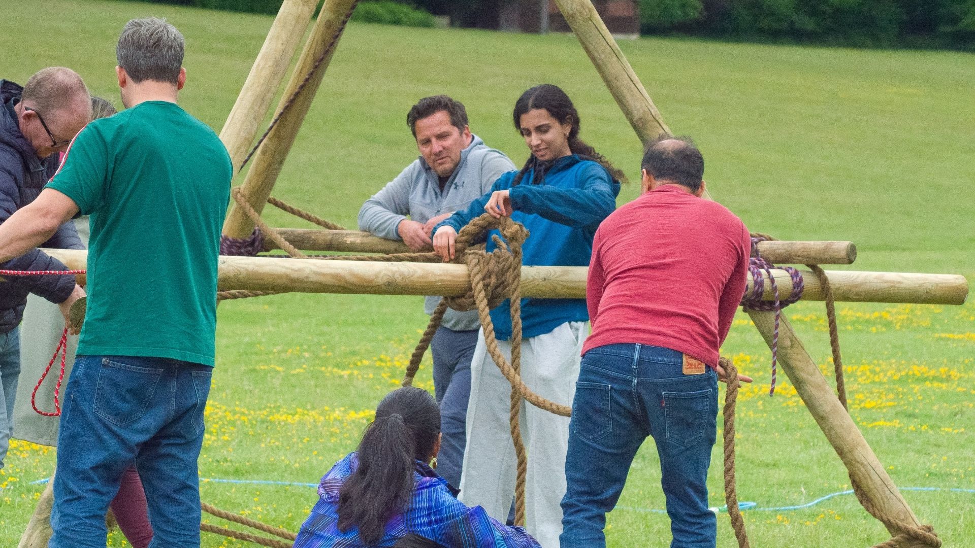 Team assembling a pioneering tripod frame with ropes at an Into The Woods bushcraft weekend