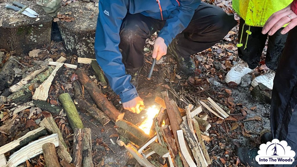 Fire Lighting - hands striking ferro rod, sparks in woodland