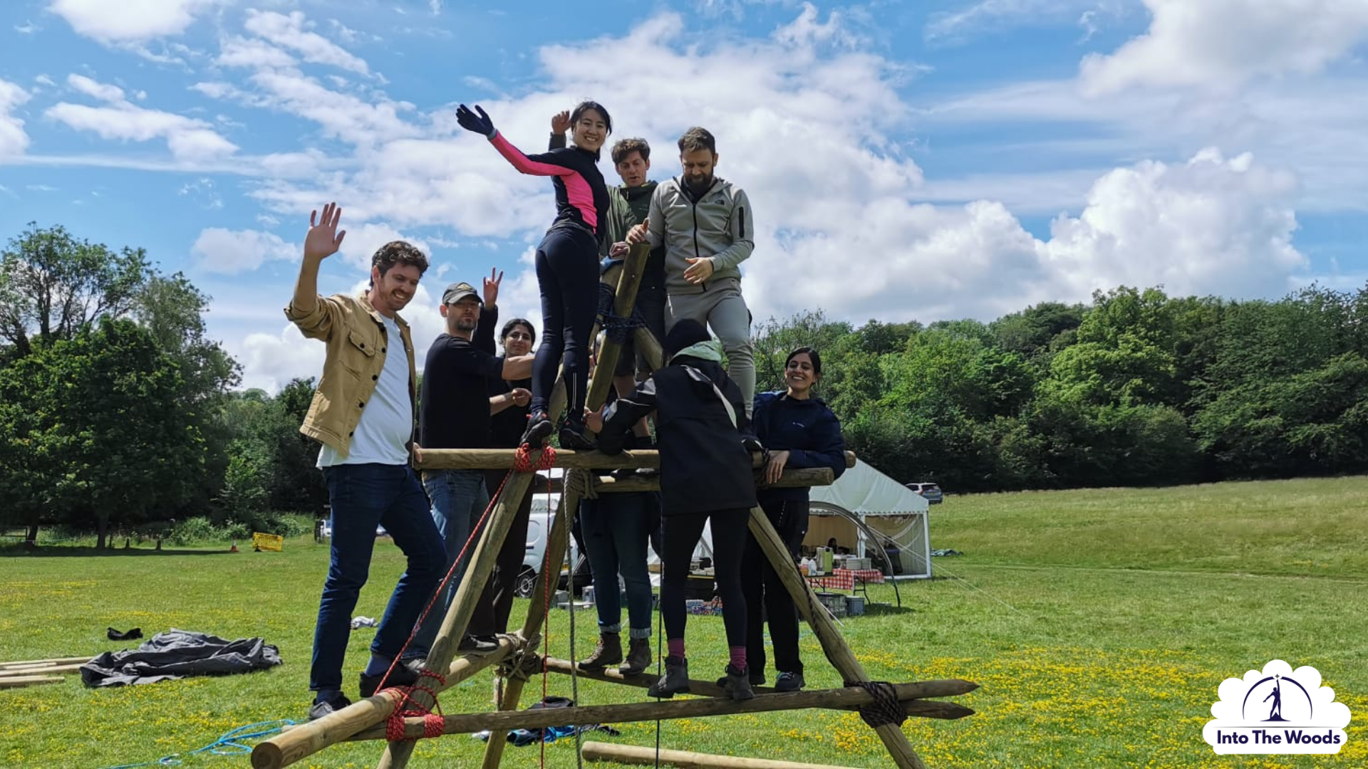 Team constructing a large wooden A-frame structure during a corporate team building day