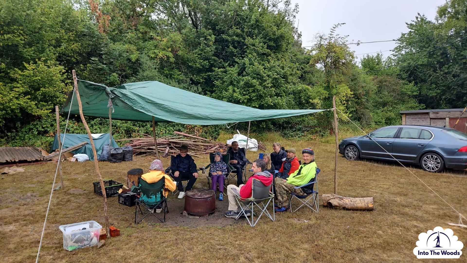 Wellness Days Kent - group relaxing around the fire under a tarp
