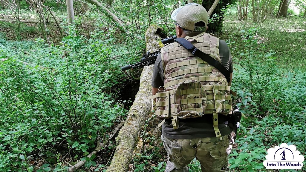 Airsoft - player in tactical gear moving through woodland