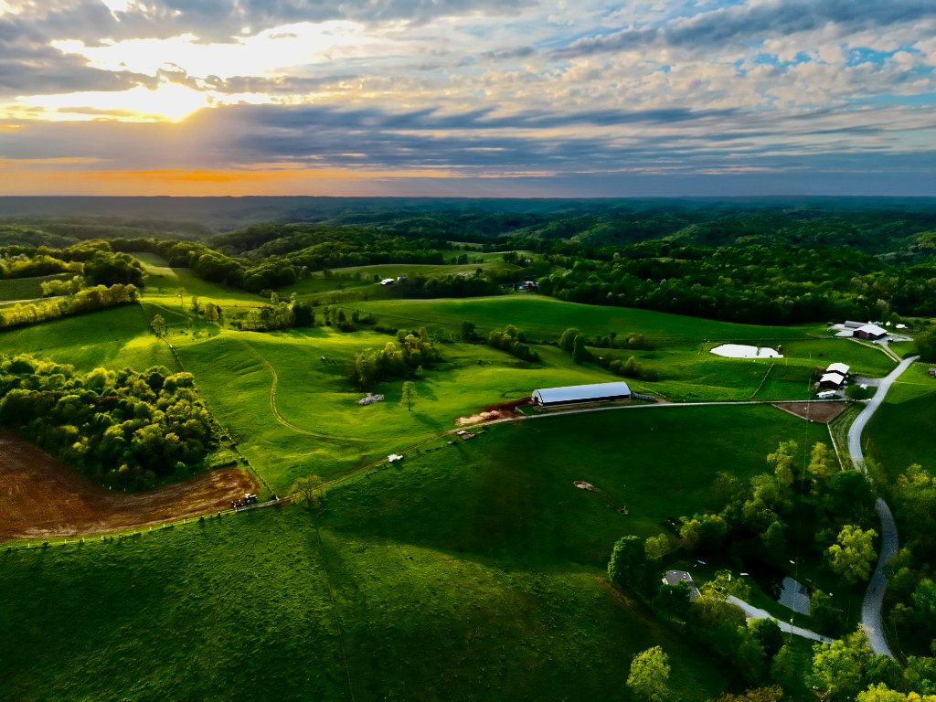 Stunning aerial photograph of rolling green Ohio farmland and forests at golden hour sunset