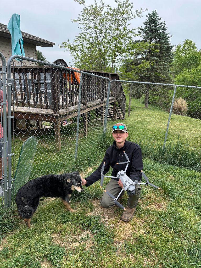 Drone operator kneeling with a dog after a successful pet recovery mission