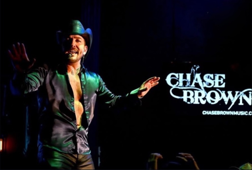 Arms open before the Chase Brown backdrop