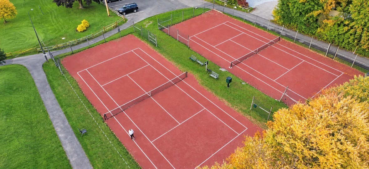 Aerial view of the two red clay tennis courts at Greenock Country Club