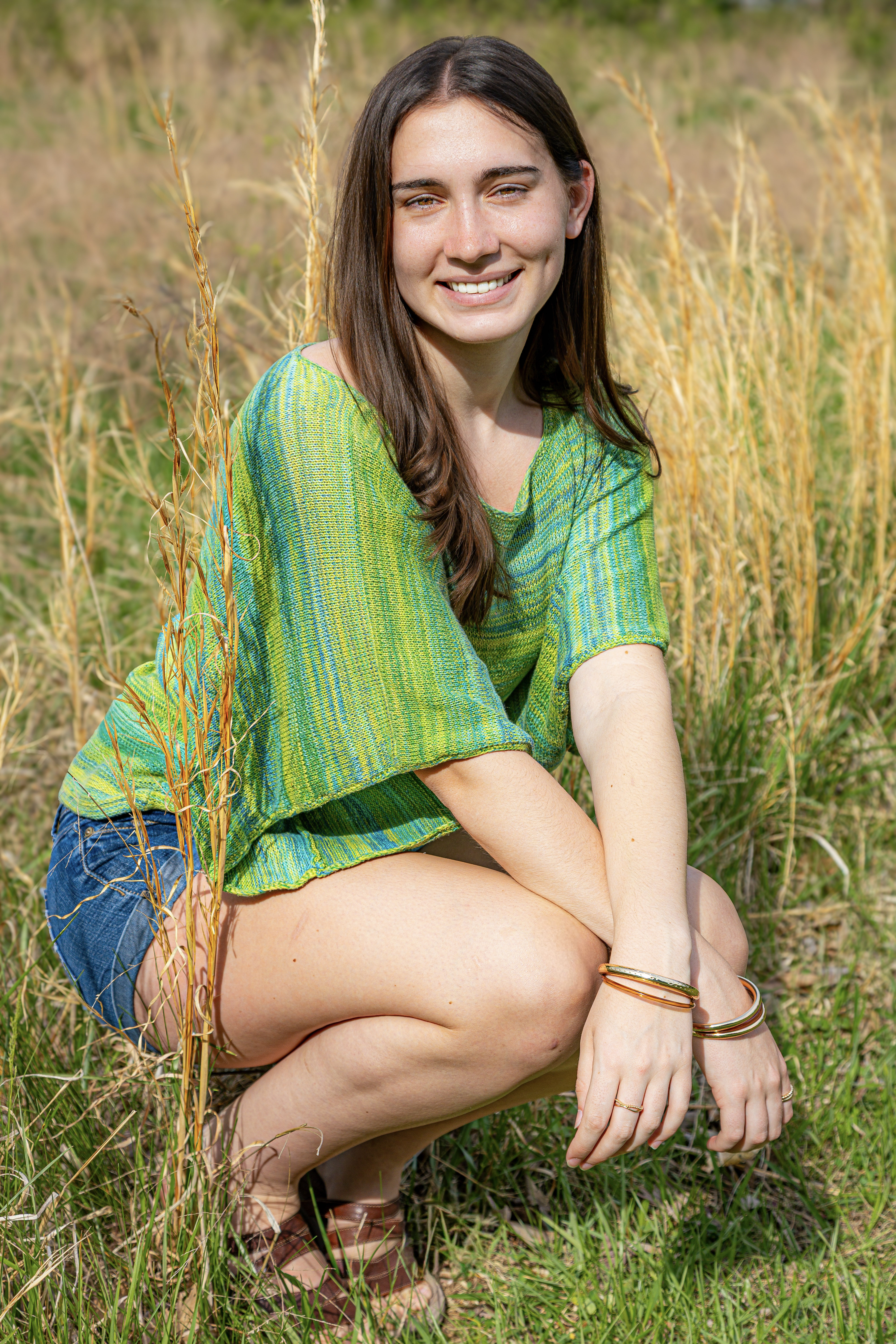 Senior portrait in a golden meadow with a bright smile