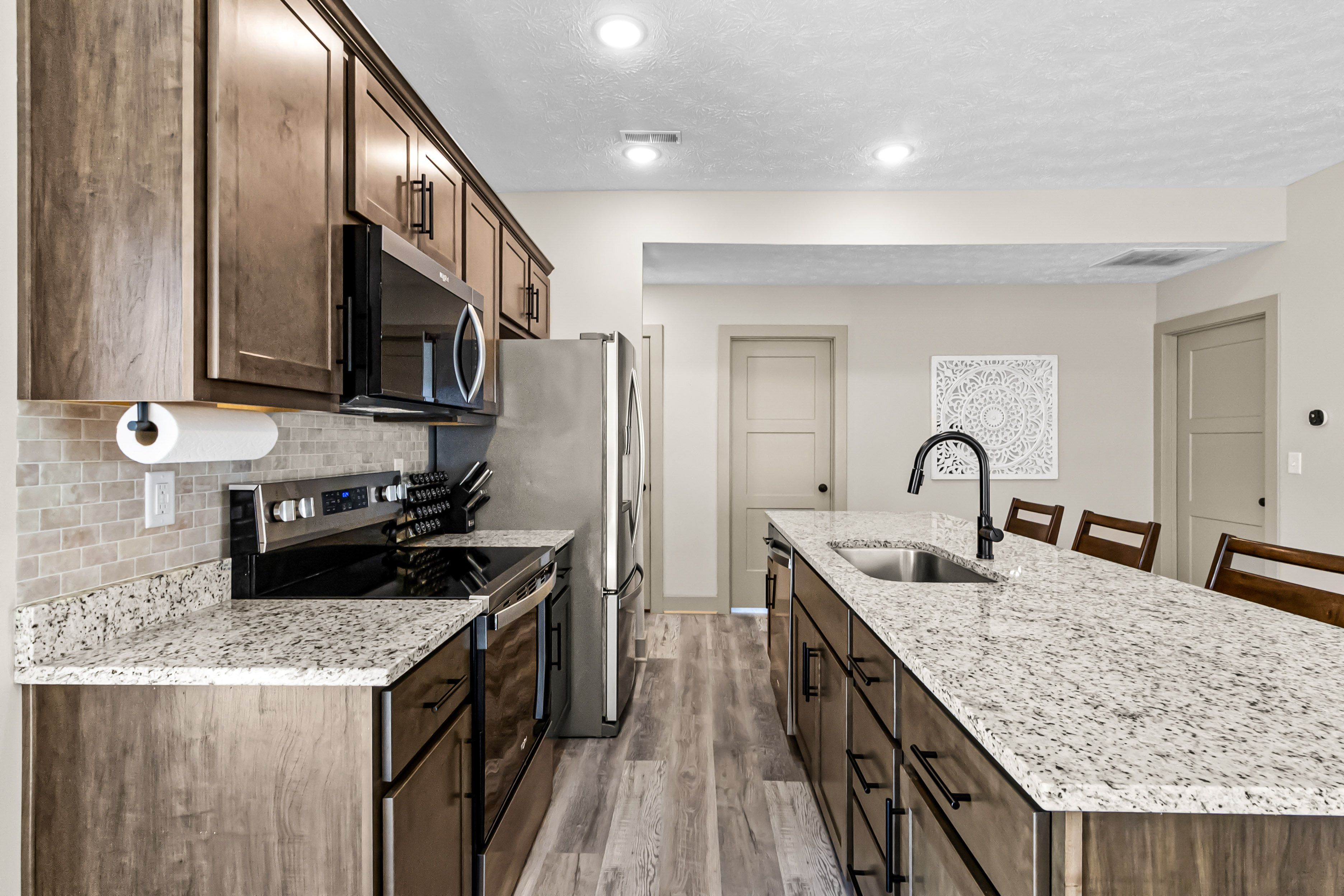 Modern kitchen with dark cabinetry and granite-topped island