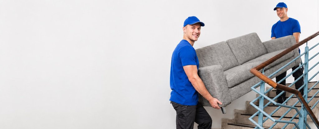 Entrümpelungsteam trägt Sofa die Treppe hoch