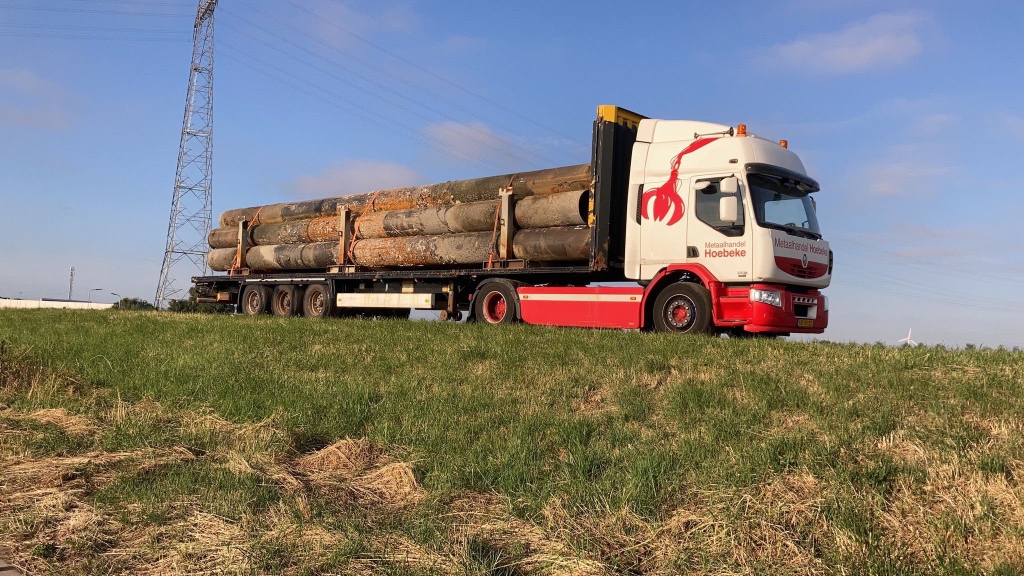 Renault vrachtwagen Hoebeke met buizen op oplegger in de polder