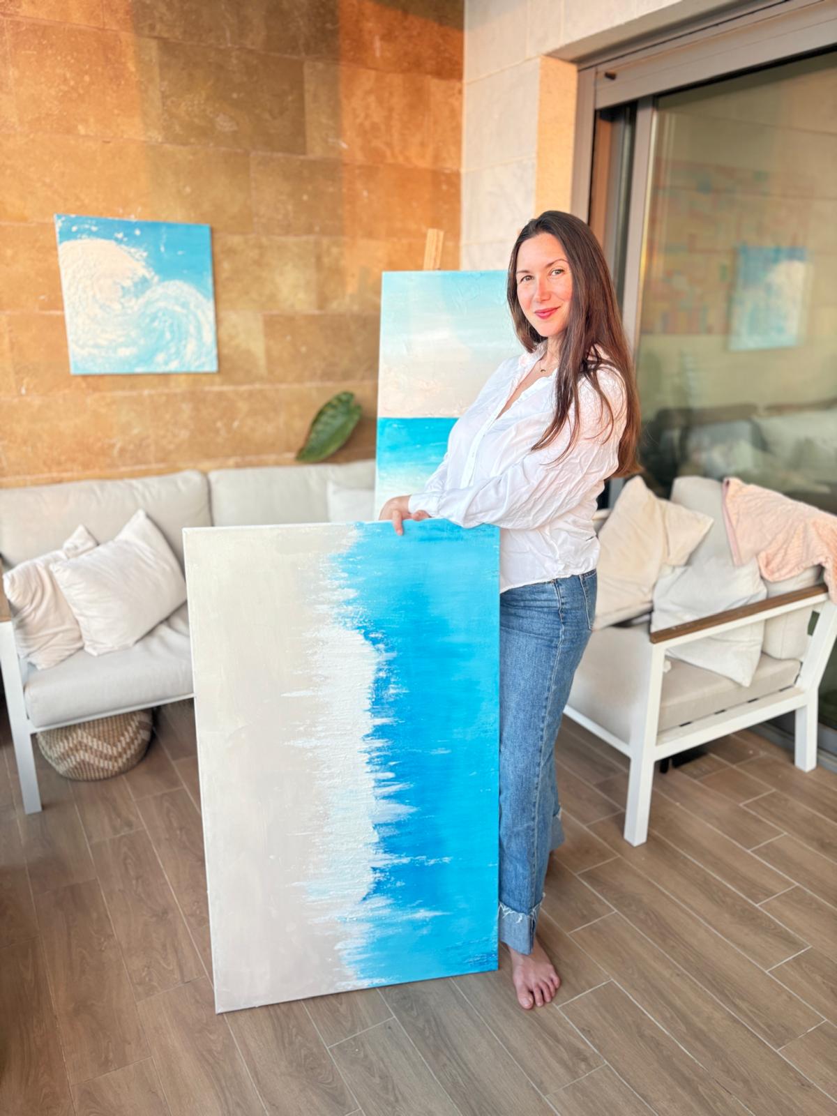 Ellen Goldes in her sun-drenched minimalist art studio, surrounded by textured paintings