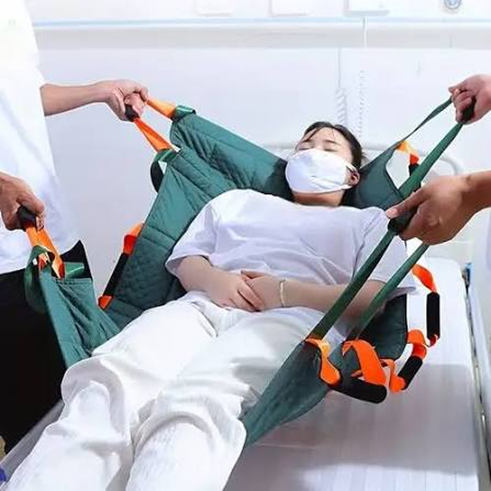 Nurses manually repositioning a bedridden patient — labor intensive and risky