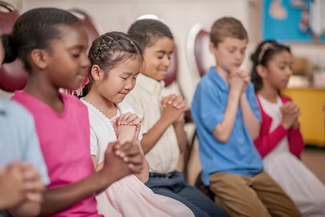 Children praying together at St. Timothy's