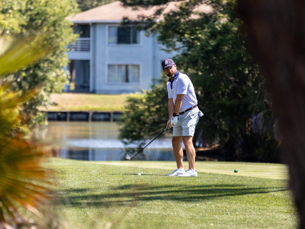 Golfer blasting out of a bunker with sand exploding