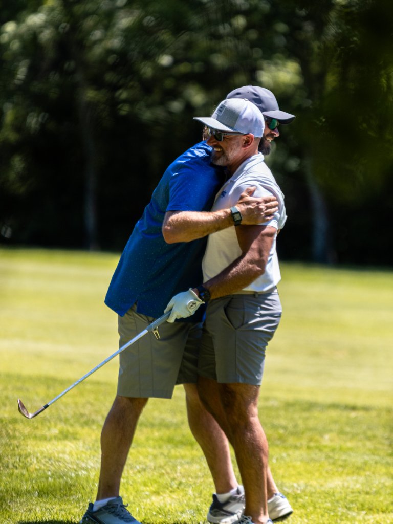 Two golfers embracing and celebrating on the fairway