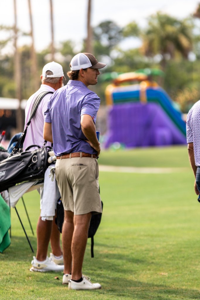 Two women golfers getting pumped up selecting clubs by their bags