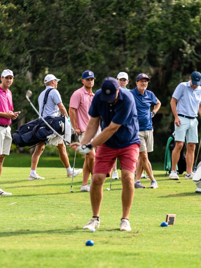 Female golfer carrying her colorful bag and flamingo headcover across the fairway