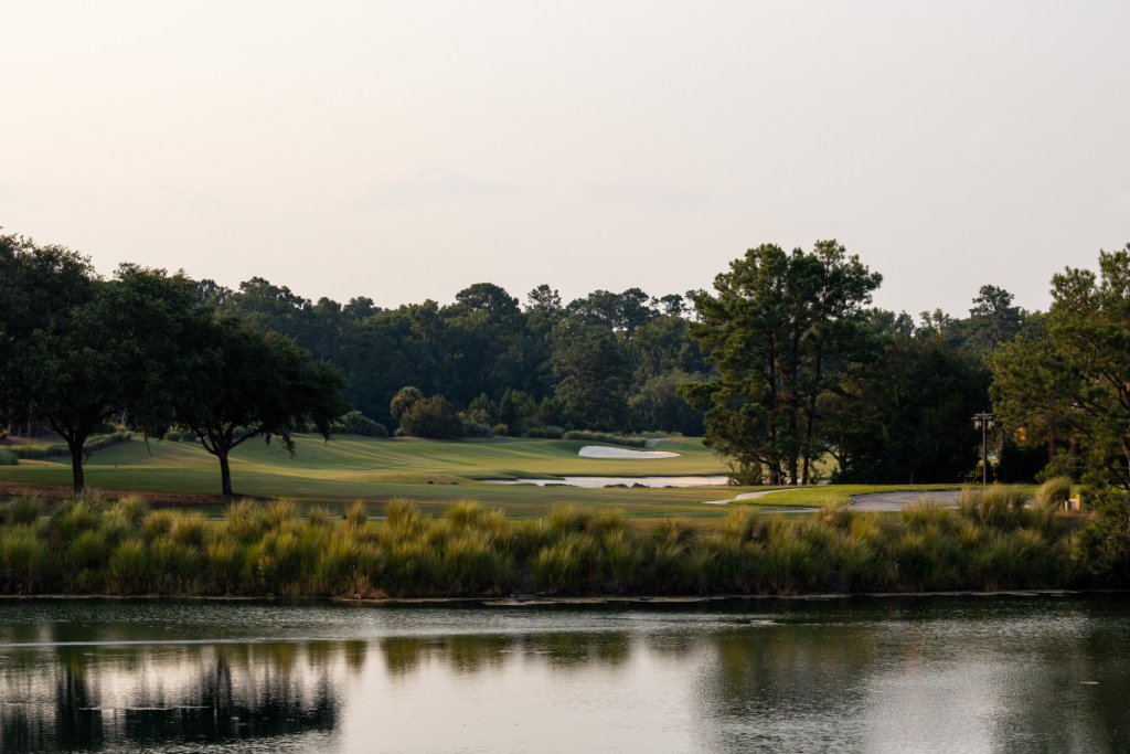 Scenic fairway reflected in a calm water hazard at sunrise