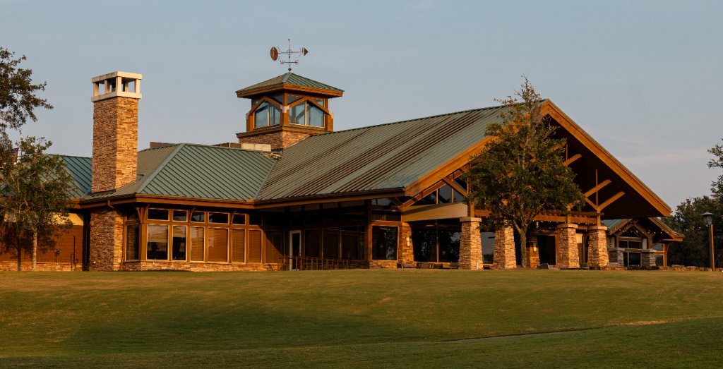 Rustic clubhouse at golden hour with stone and timber architecture
