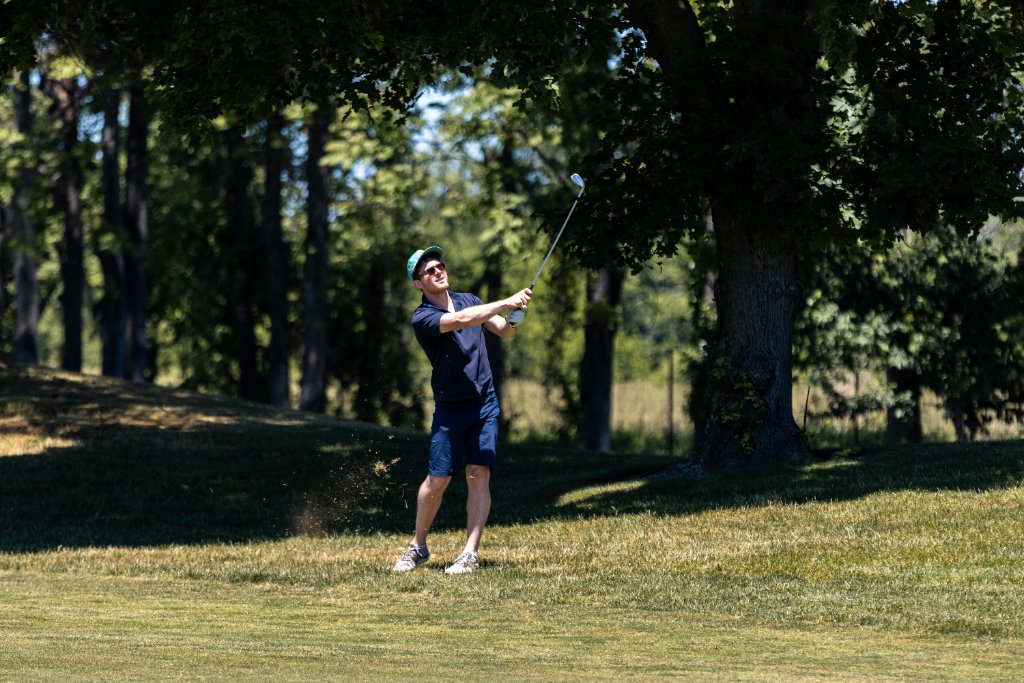 Golfer hitting an iron shot off the fairway