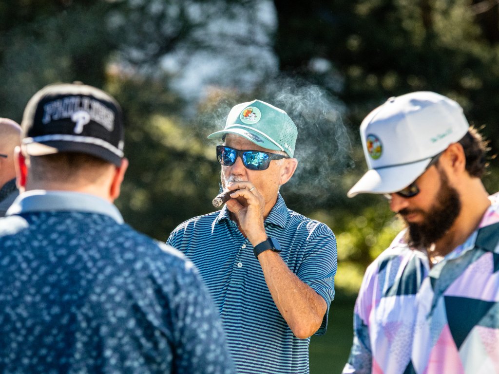 Group of golfers chatting between holes with a cigar