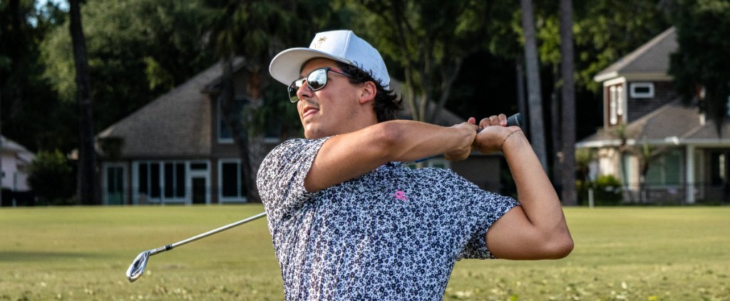 Young golfer finishing a swing on a beautiful course