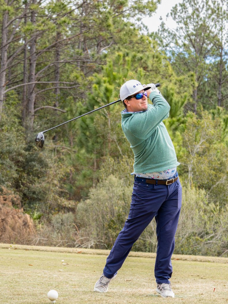 Golfer hitting a driver on a beautiful course in winter