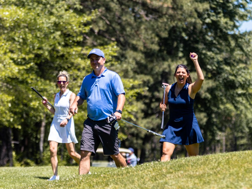 Group of golfers celebrating as they walk up the fairway