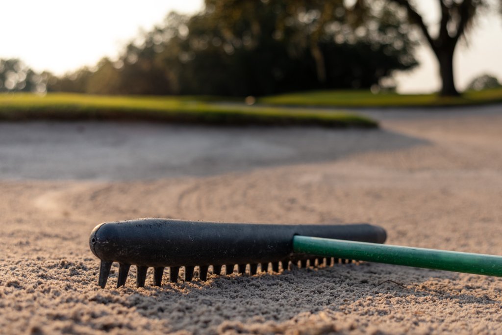 Bunker rake resting in the sand trap at golden hour