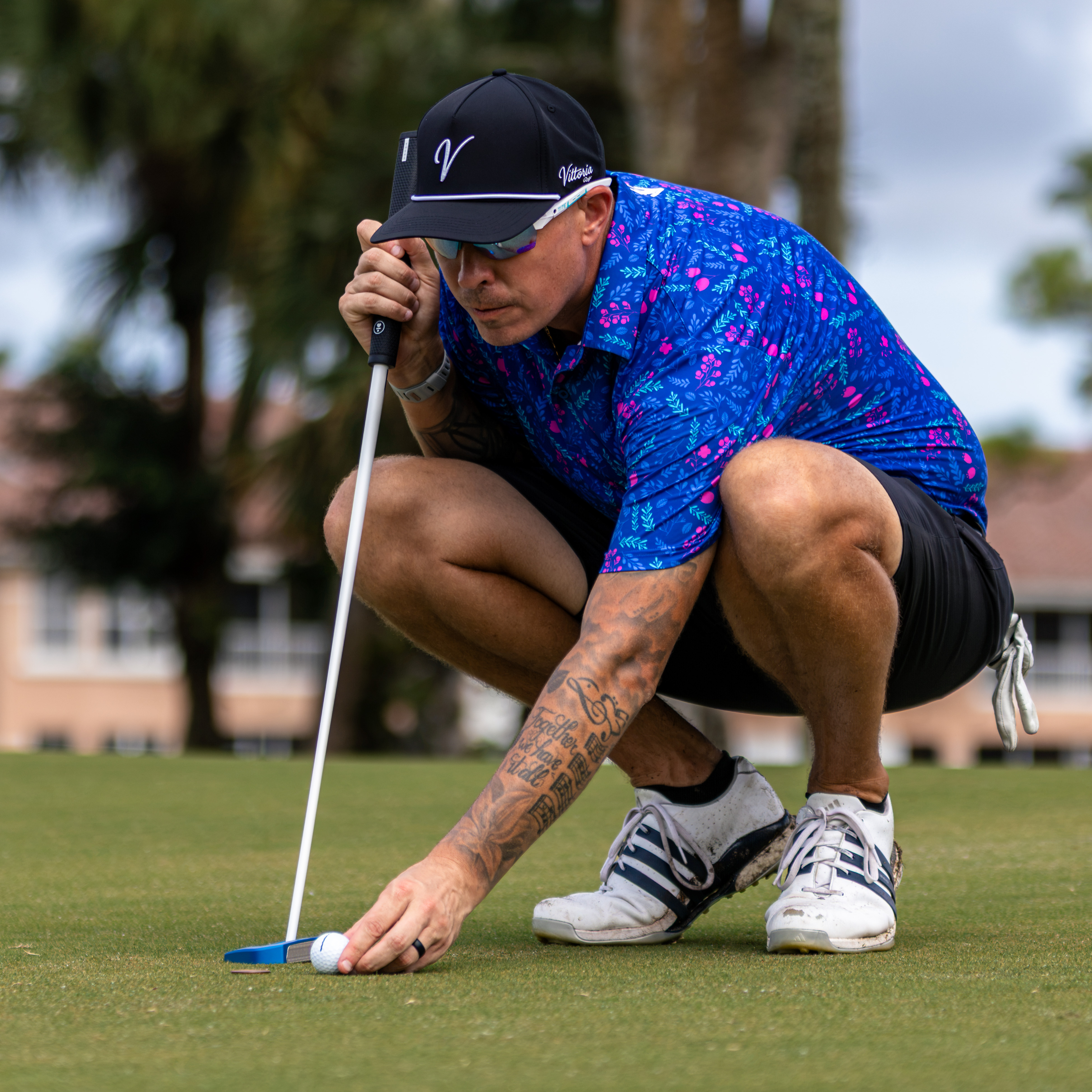 Golfer crouching low to read the line of a putt on the green