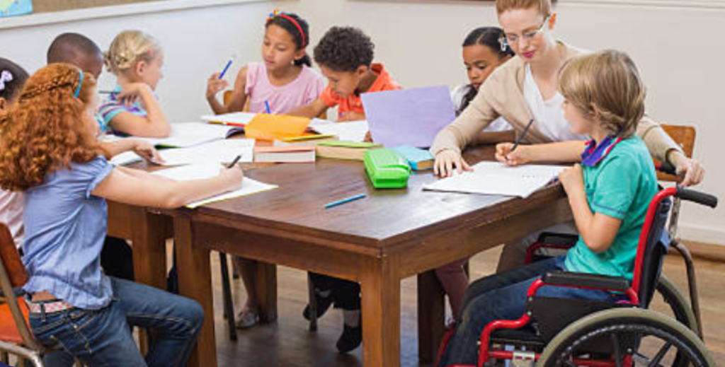 Students and teacher working together at classroom table