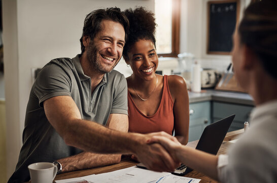 Happy couple shaking hands with insurance consultant