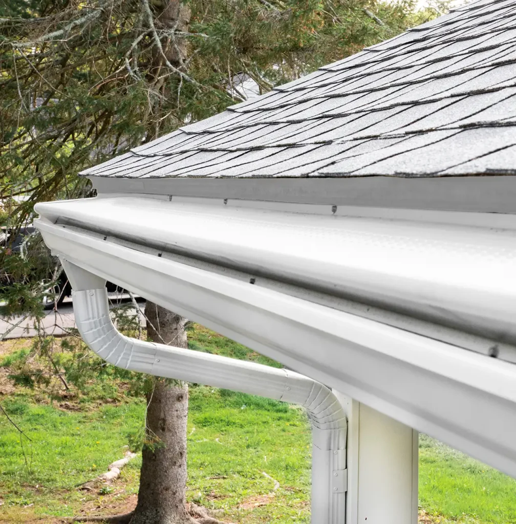 White seamless gutter system with gutter guard installed on Utah home