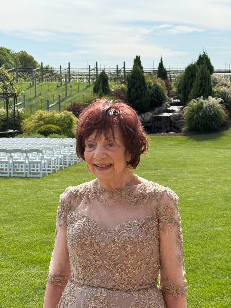 Client Arlene wearing a natural hair topper styled by Shaina, outdoors at a garden event