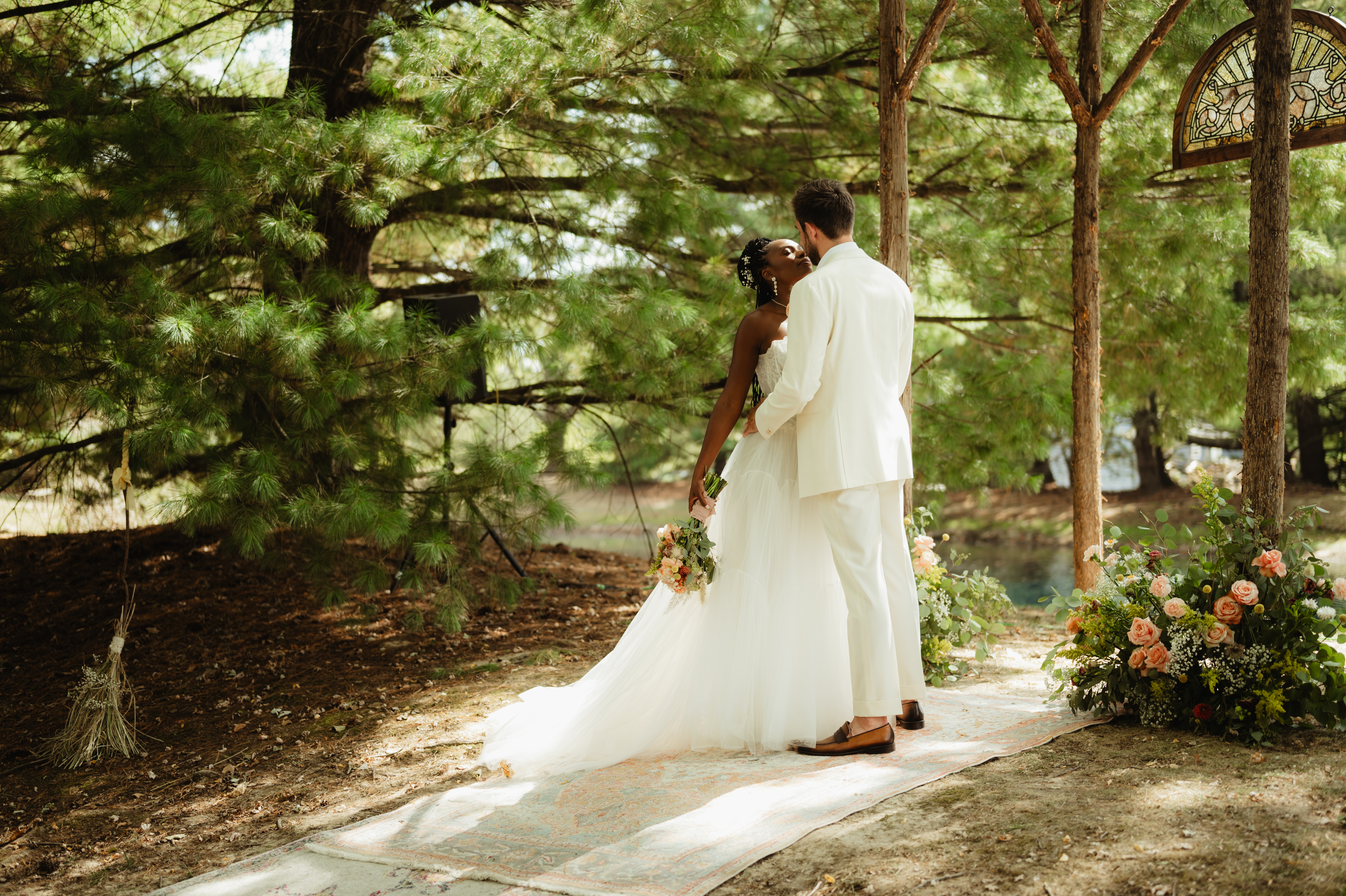 Couple kissing in a wooded ceremony setting