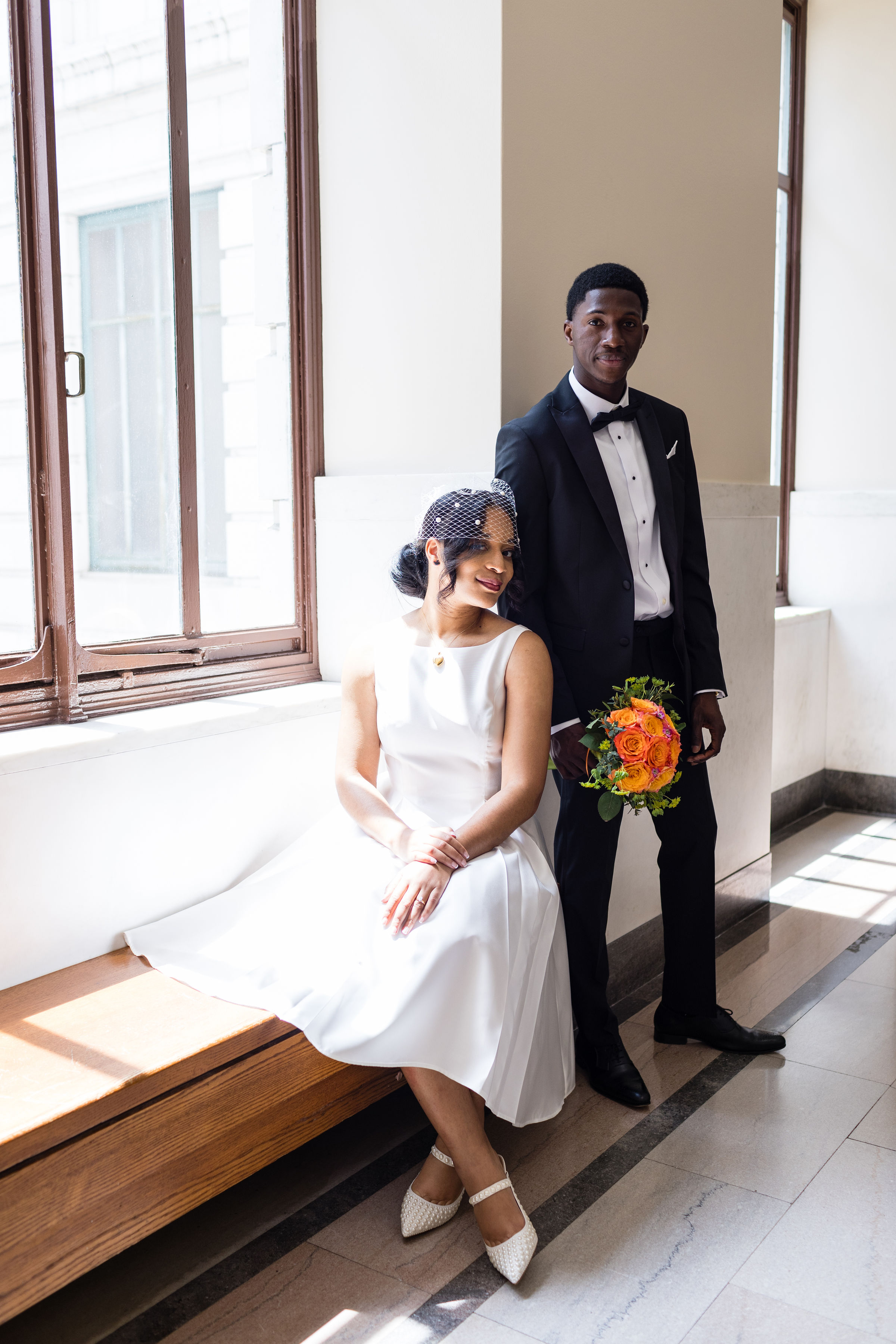 Bride seated on a bench beside the groom