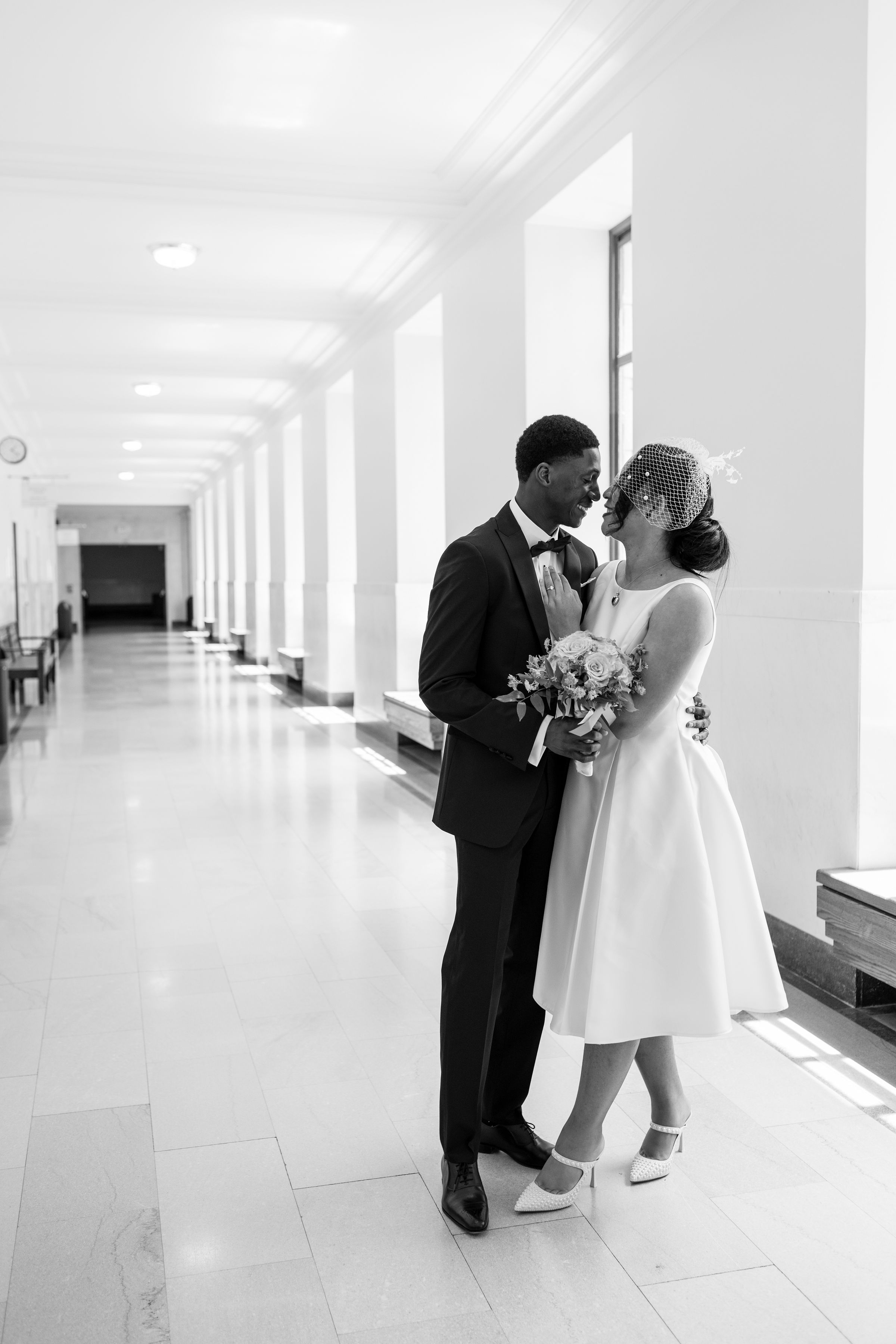 Newlyweds in a grand hallway on their wedding day