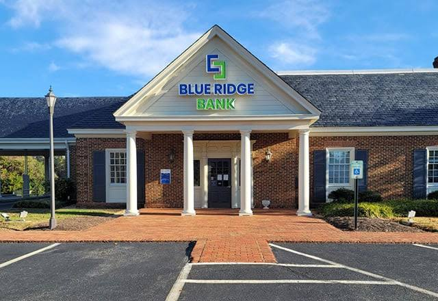 A Blue Ridge Bank branch — brick façade and white columns under a clear sky