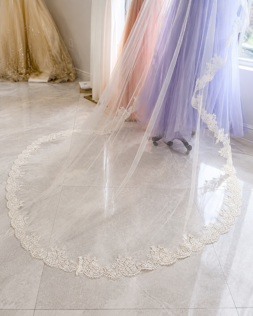 Cathedral length bridal veil with lace trim displayed on boutique floor at Bridal and Couture Alterations