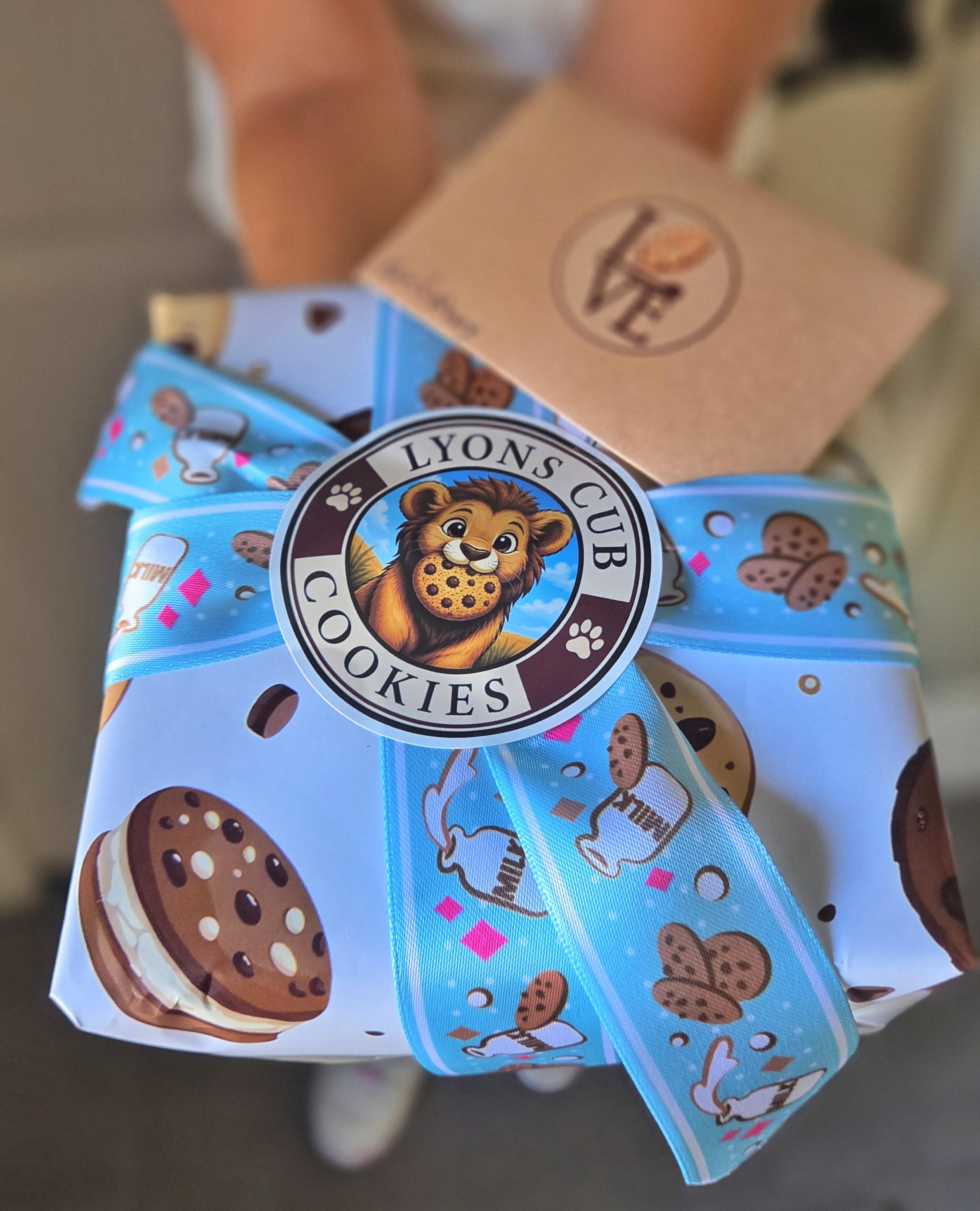 Open gift box packed with chocolate chip and powdered sugar cookies