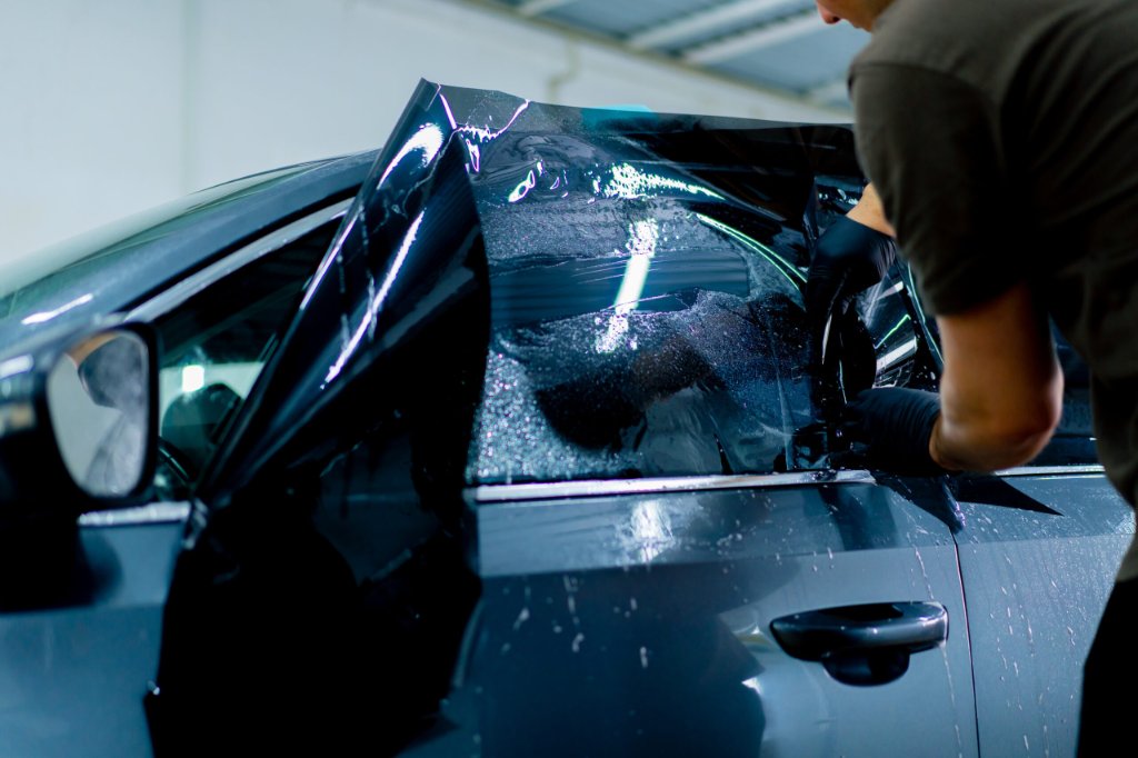 Technician applying window tint film