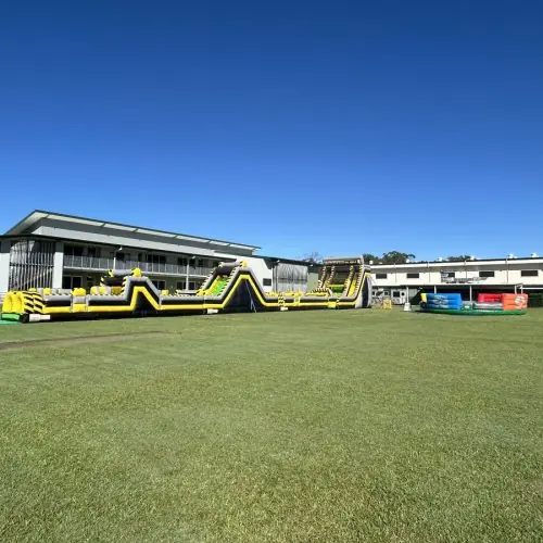 Epic inflatable obstacle course set up on a school oval for vacation care