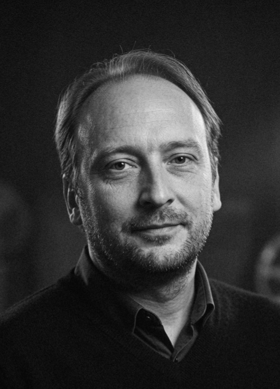 Black and white portrait of the author in a library setting