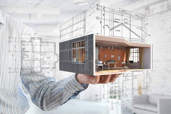 Architectural blueprint wrapped around a 3D isometric office model held in hand