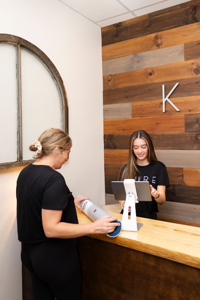 KURE MOVEMENT STUDIO reception desk with a large K on the wooden feature wall