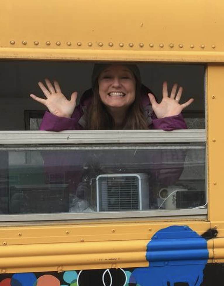 Hands up through a yellow school bus window — real work, in the field