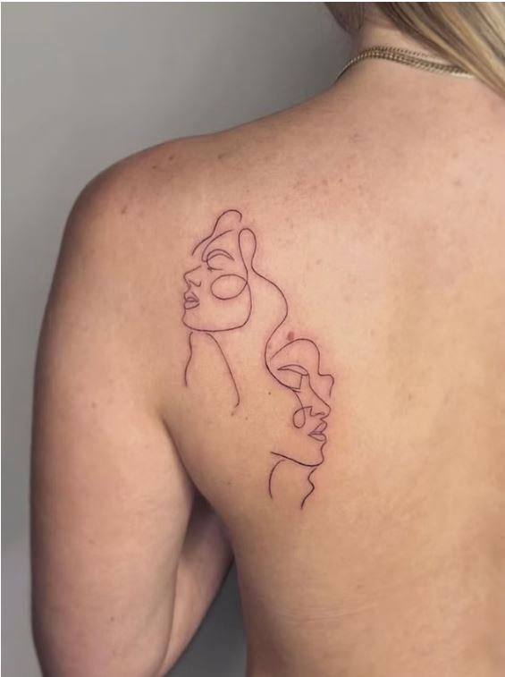 Minimalist line-art faces tattoo on upper back