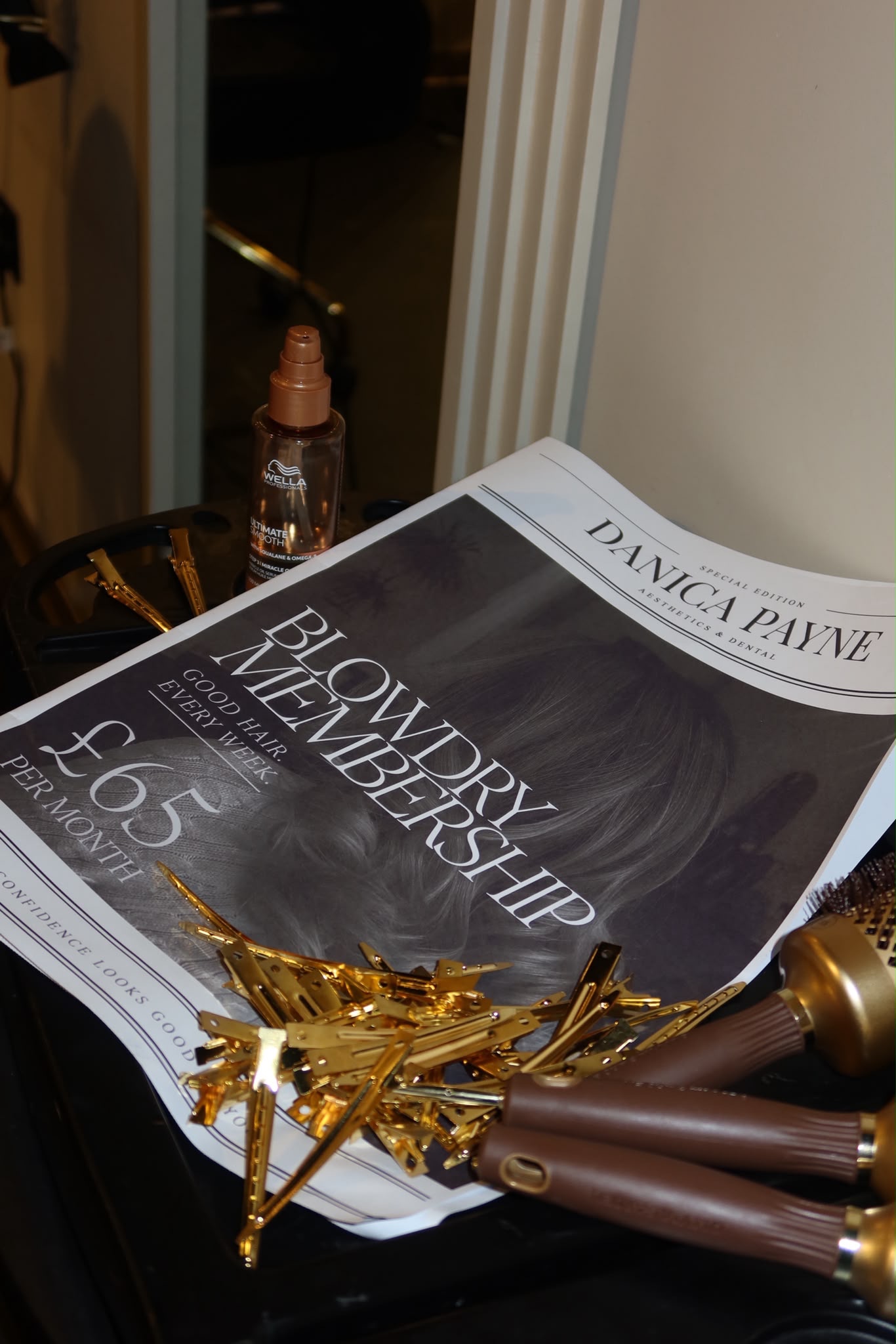 Danica Payne blow dry membership card on a black tray with gold hair clips