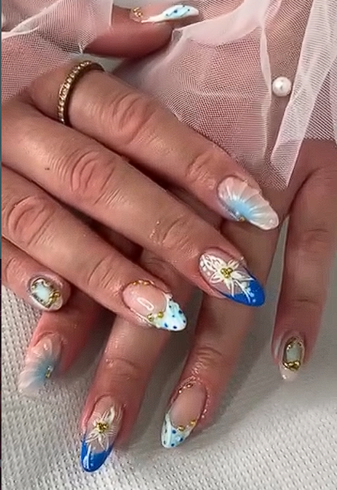 French manicure with blue and white floral motifs and gold bead embellishments